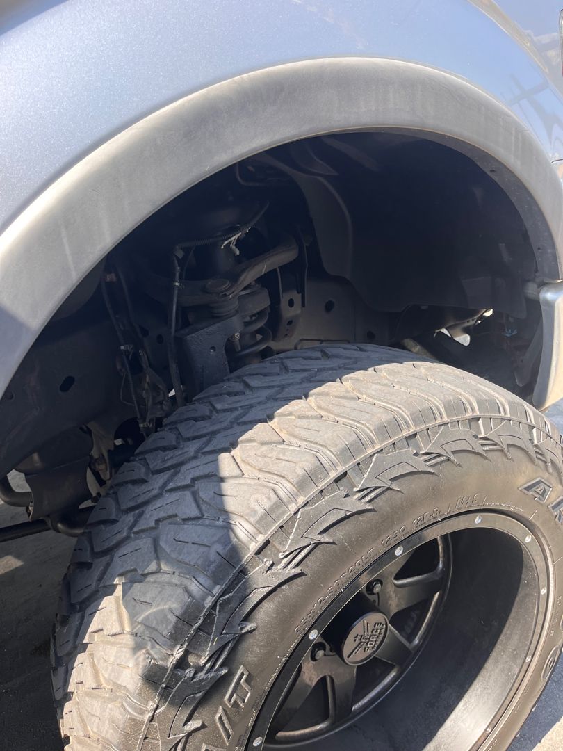 Tire and wheel-well check on a lifted truck