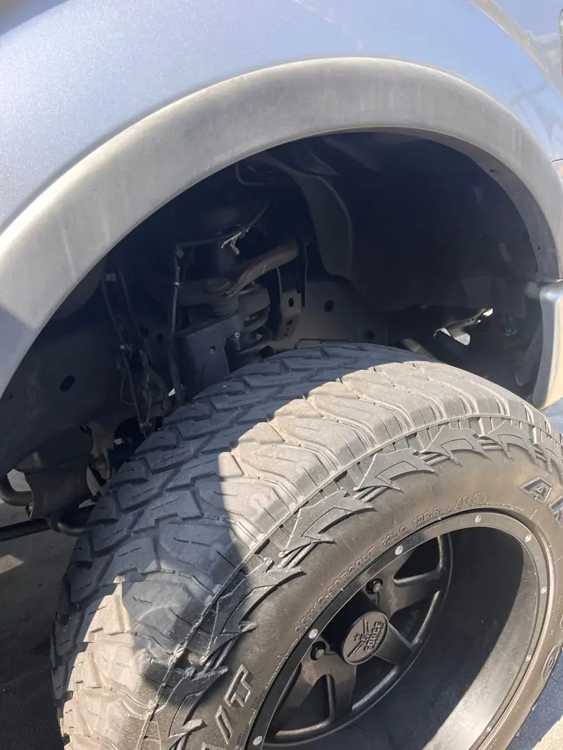 Tire and wheel-well check on a lifted truck
